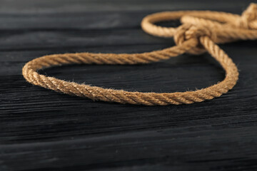 Lasso made of cotton rope on black wooden background, closeup