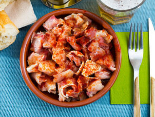 Top view of traditional spanish tapa Orejas de cerdo - braised pig ears served in clayware ..