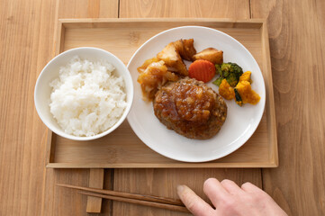 ご飯と玉ねぎソースのハンバーグに野菜のソテーが添えられたプレート