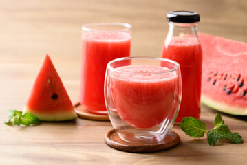 Fresh watermelon juice in glass and bottle on wooden background, Summer drink