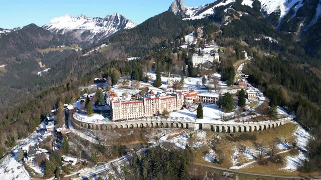 Establishing drone shot of Caux Palace Hotel with snow during the day in the village of Caux, canton of Vaud, Switzerland