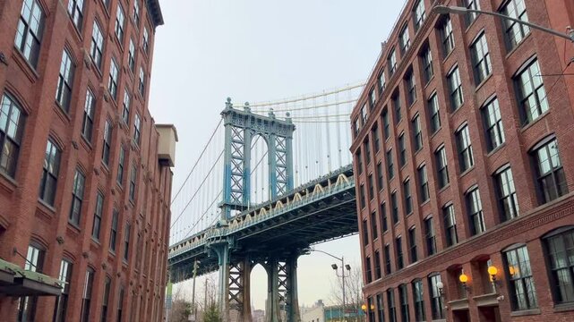 Manhattan Bridge in Dumbo, Brooklyn, New York City on a cloudy day in between two apartment buildings