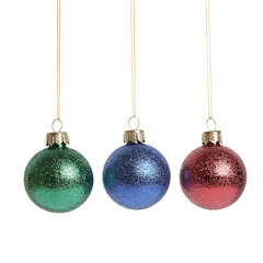 Sparkling glass ornaments hang elegantly against a bright white background a festive trio of jewel-toned spheres.. AI Generated