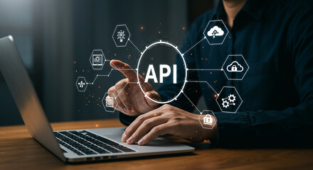 Person using laptop with api interface and icons representing cloud computing and data security...