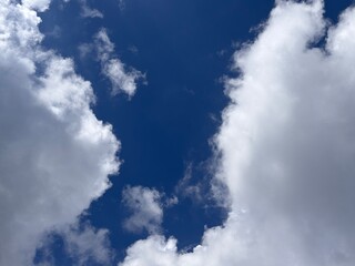 Beautiful blue sky with white clouds. The sky was clear and bright, and clouds were scattered all over the sky. The scene was peaceful and serene, as if the viewer was gazing at a beautiful day.