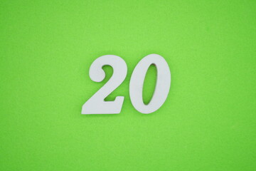 The numbers are made of white painted wood placed on a green paper background.