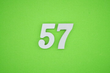 The numbers are made of white painted wood placed on a green paper background.