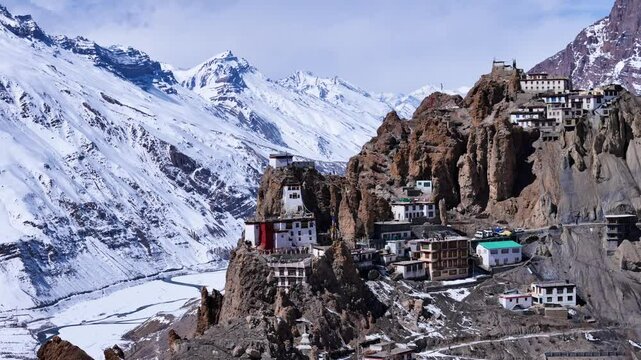 Aerial drone shot highlighting the rugged beauty of Dhankar Monastery in winter, as it stands proudly amidst the icy wilderness of Spiti Valley.