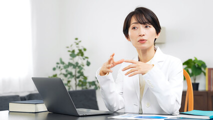 会話する白衣のミドル女性