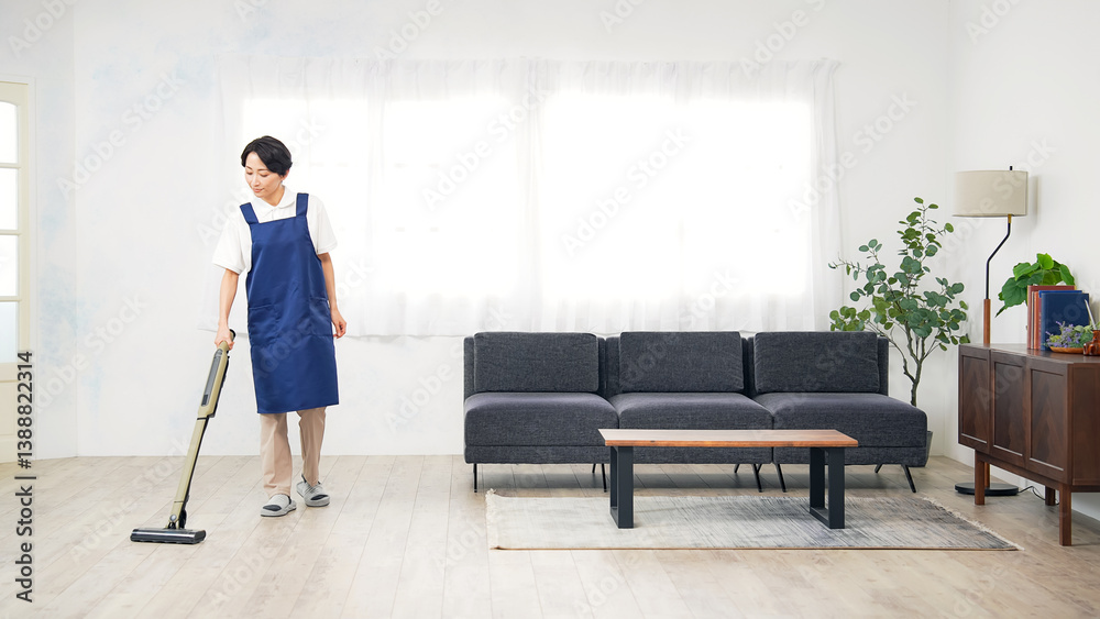 Poster 部屋の床に掃除機をかけるエプロンをつけたミドル女性