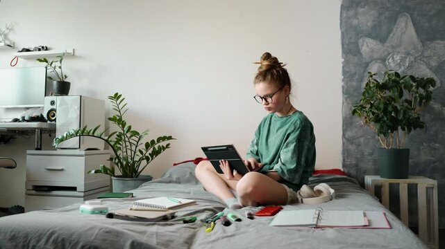 Young woman studying online course, writing down insights on tablet. Self-paced learning allows flexibility and better knowledge retention. Concept of digital education and self-improvement.