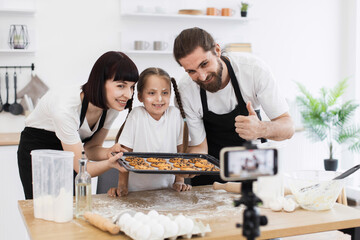 Caucasian family of blogger chefs baking cookies, featuring a man, woman, and a child.