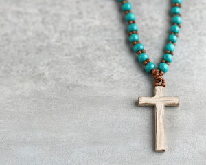 Rosary jesus christ concept. Turquoise bead necklace with a silver cross pendant on a textured background.