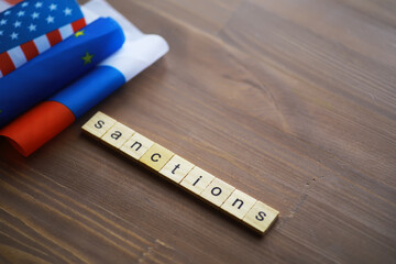 Sanctions Concept with Scrabble Letters and National Flags on Wooden Background