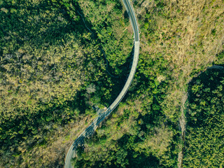 aerial top view above Huai Tong Bridge.. Forest River Bridge under a Blue Sky with Green Landscape and Mountain Views, .featuring Trees