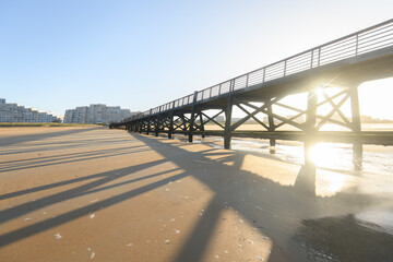 Obraz premium Ponton, plage et immeubles du littoral maritime au lever du soleil, l'estacade de Saint Jean de Monts en vendée