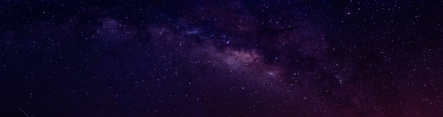 Milky way in night sky and stars on dark background with noise and grain. Long exposure and white...