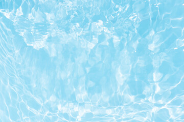 Blue water with ripples on the surface. Defocus blurred transparent blue colored clear calm water surface texture with splashes and bubbles. Water waves with shining pattern texture background.