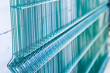 Welded mesh for fence in green color, several sections of transparent fence