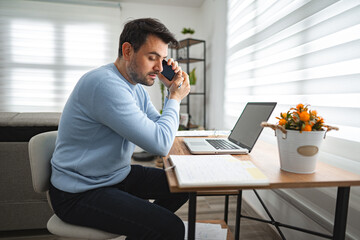 Man Sitting at Desk Talking on Cell Phone