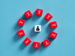 Saving money by cutting expenses, cost reduction concept with dice and scissors icons surrounding...