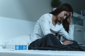 Young woman sleepless during night time on the bed.
