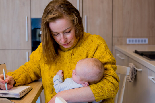 Tired mother working from home with baby