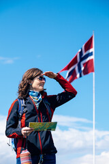 female tourist with norwegian flag in the background