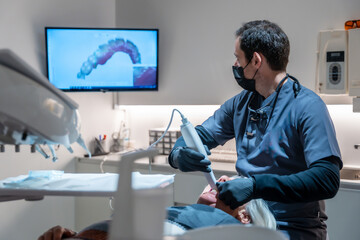 Dentist performing 3d scan of patient's teeth in modern dental clinic