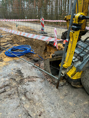 Fenced excavations in the ground along the road during construction of the sewage system