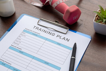 Training plan paper set on clipboard with dumbbell on the side, for gym and exercise themes. © Kamitana