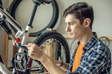 Man is performing maintenance on his mountain bike. Concept of fixing and preparing the bicycle for...