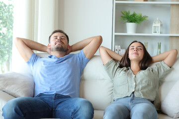 Happy couple at home relaxing and resting on a couch