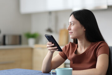 Distracted asian woman looking away holding phone