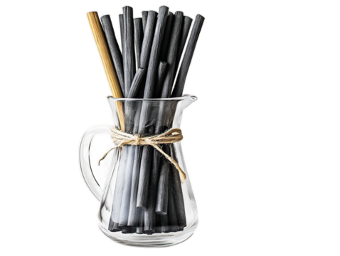 Bamboo charcoal water filter sticks in glass carafe, natural water purification system on white background