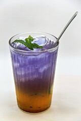 Refreshing Indonesian drink made with passion fruit and butterfly pea flower, Es Markisa Bunga Telang. Naturally vibrant with a sweet and tangy flavor, served cold with ice.