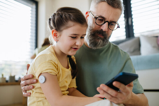 Diabetic girl with a CGM sensor on her arm.