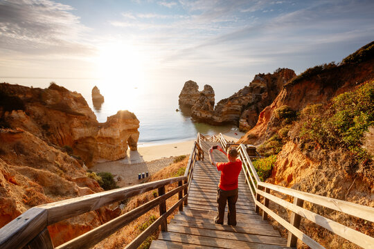 Man at Camilo beach at sunrise, Algarve, Portugal