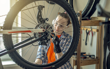 Woman is performing maintenance on mountain bike. Concept of fixing and preparing the bicycle for...