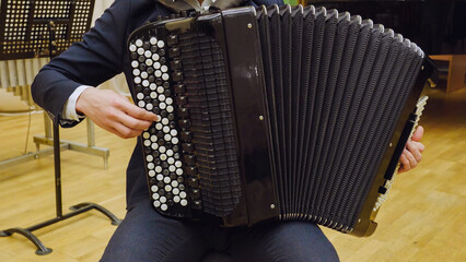 A young guy plays the accordion. Accordion close-up.