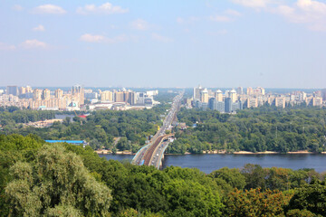 Panoramic view of Kyiv skyline with bridge, river and modern buildings