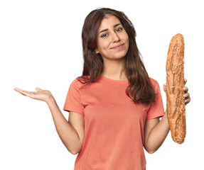 Middle Eastern woman holding bread loaf showing a copy space on a palm and holding another hand on...