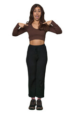 Fototapeta premium Middle Eastern woman, full body studio surprised pointing with finger, smiling broadly.