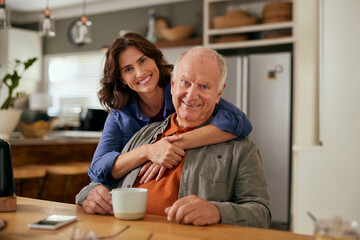 Portrait of smiling beautiful daughter embracing old father