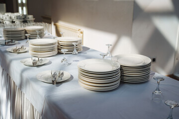 A beautifully arranged table featuring plates, elegant wine glasses, and various pieces of...