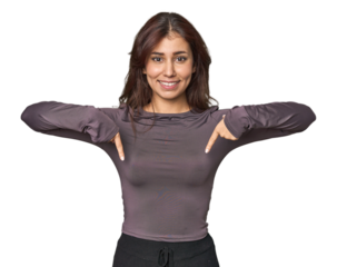 Middle Eastern woman in studio points down with fingers, positive feeling.