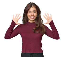 Middle Eastern woman in studio showing number ten with hands.