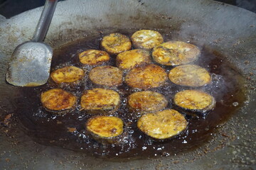 Hilsha fish is fried in a big pan along with shrimp and eggplant, Hilsha Fish and shrimp Simmering in mustard oil, traditional Bengali style fried hilsa and eggplant	