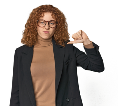 Young Caucasian redhead in business attire showing thumb down, disappointment concept.