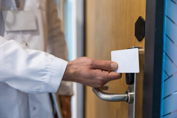 Unrecognizable doctor using access card for key scanning and digital lock